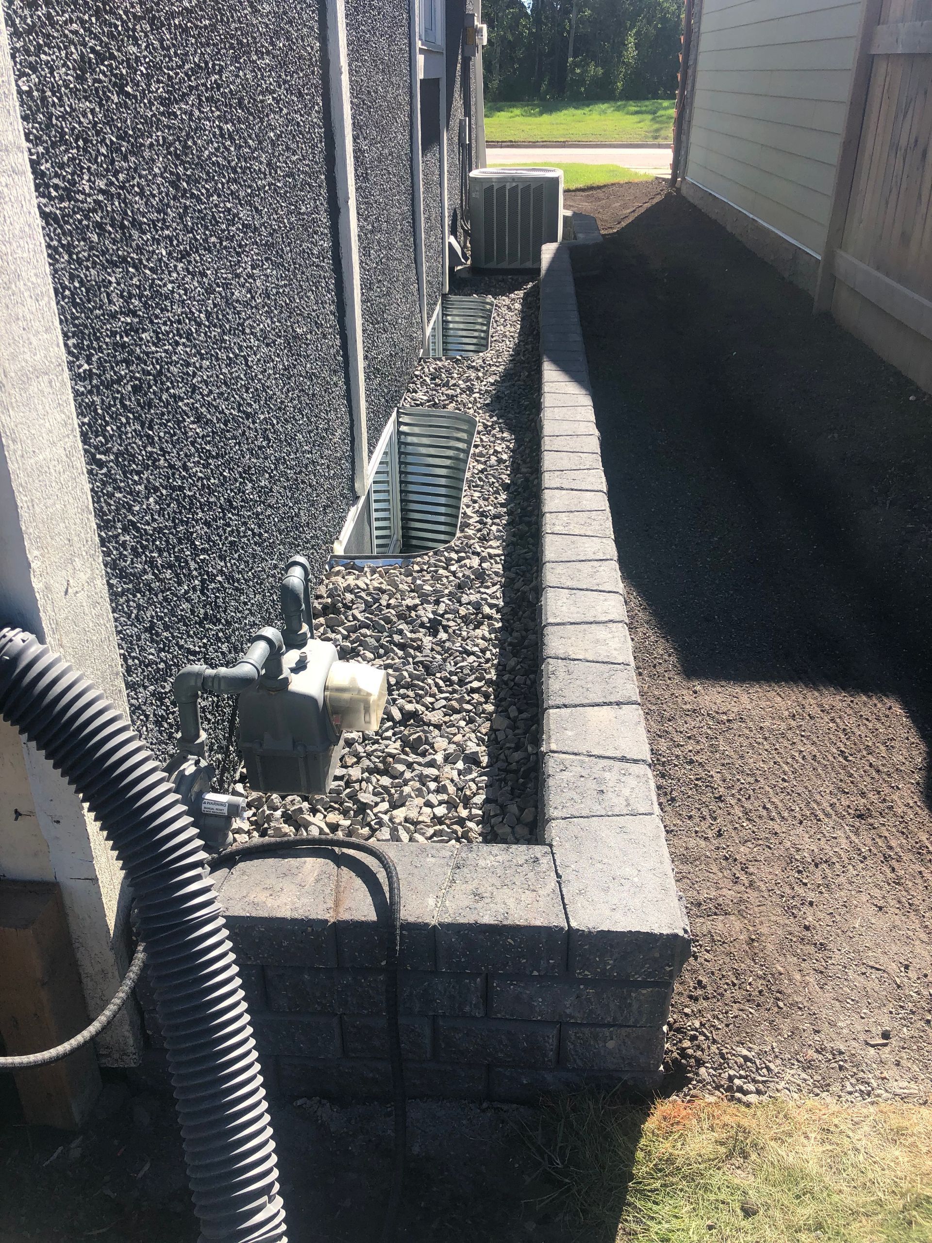 A hose is attached to a wall next to a house.