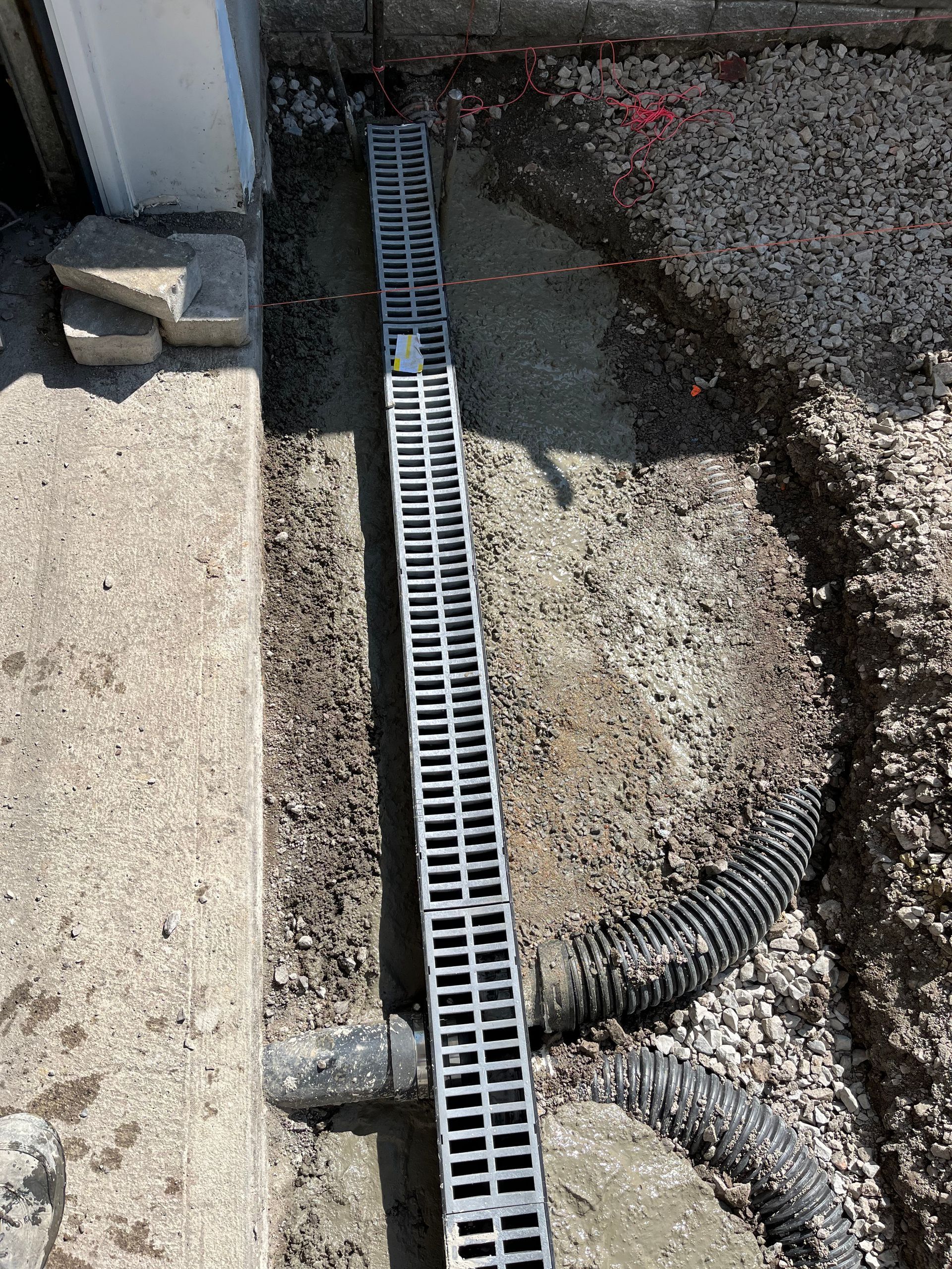 A drain is being installed on the side of a building.