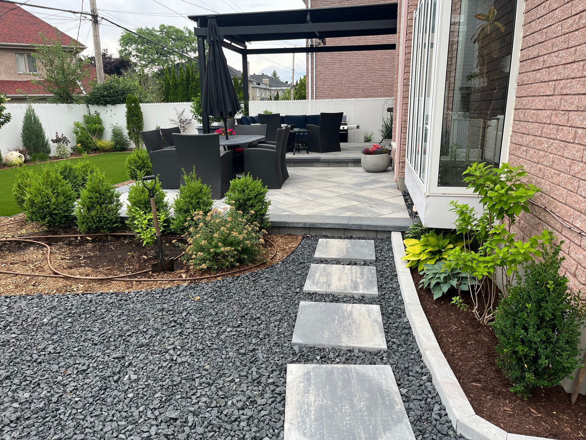 A brick house with a patio and a walkway leading to it.