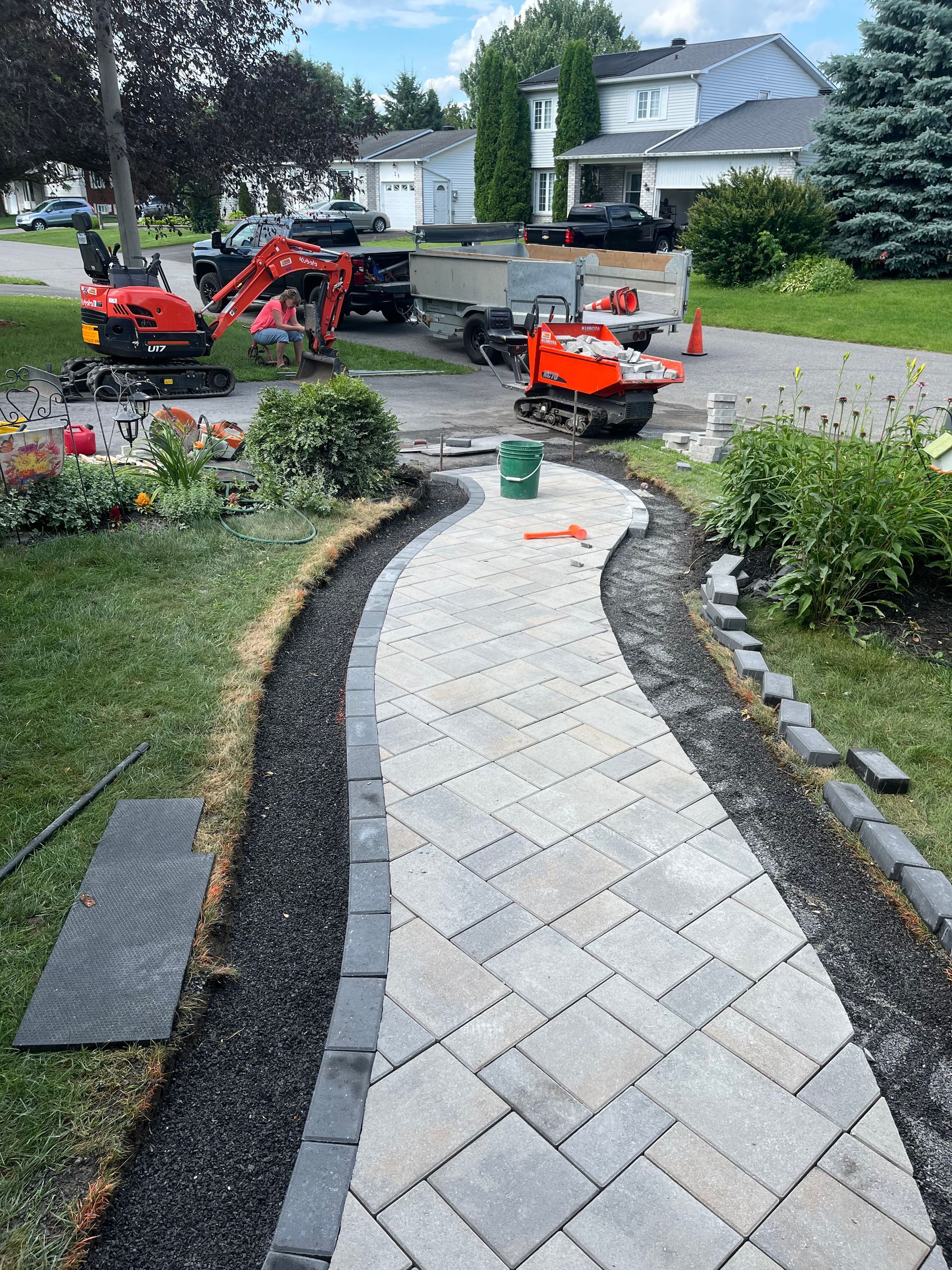 A walkway is being built in the backyard of a house.