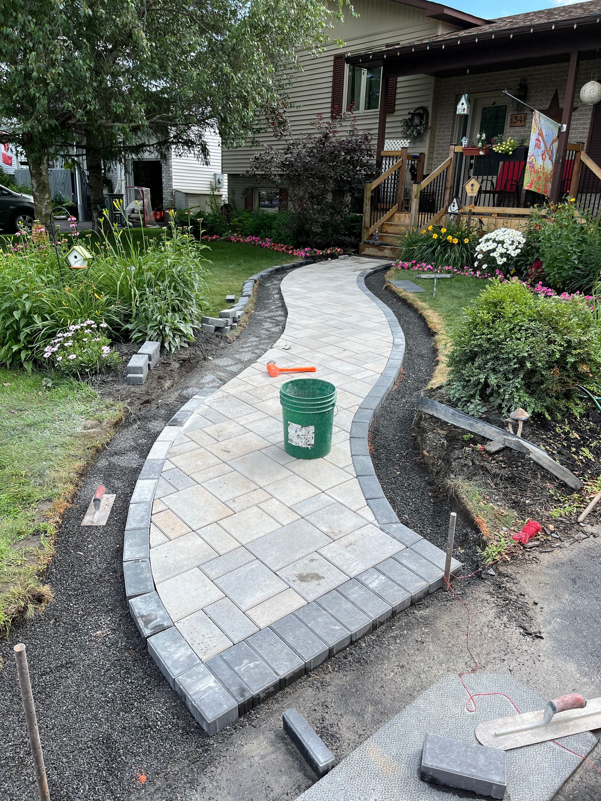 A brick walkway is being built in front of a house.