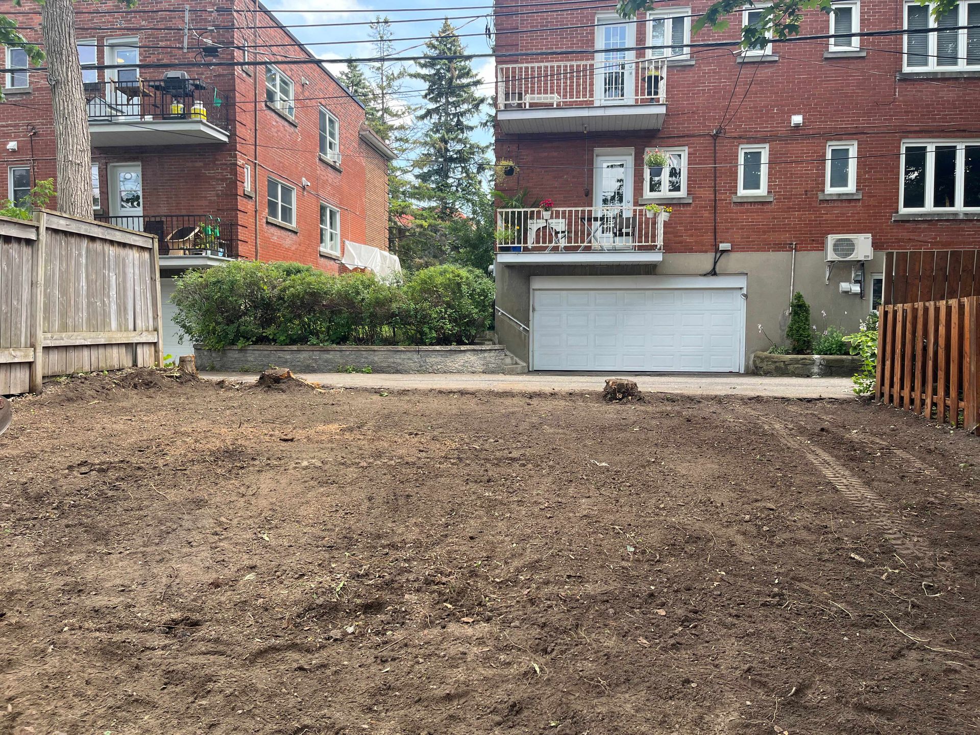 A brick building with a garage and a fence in front of it