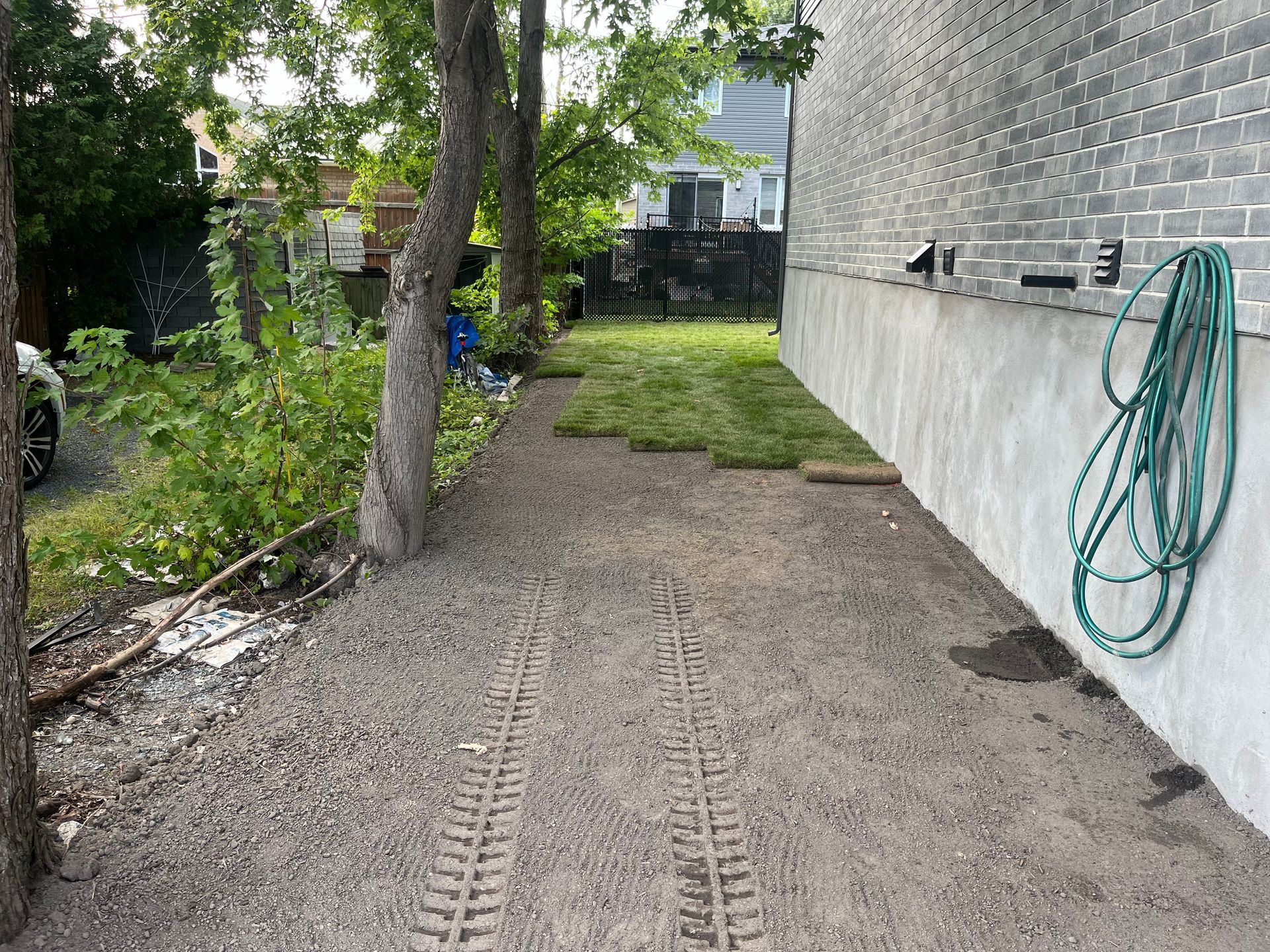 A hose is hanging on the side of a brick building.
