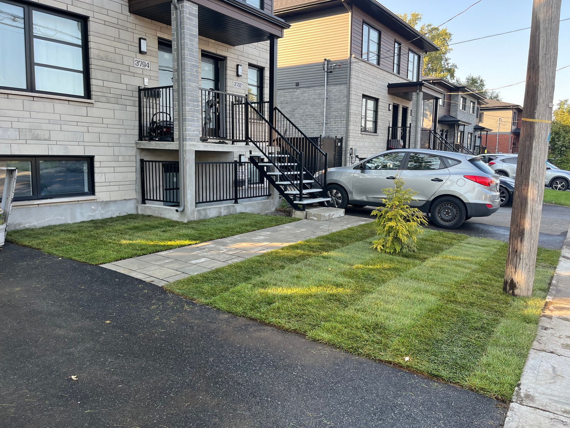 A car is parked in front of a building with stairs.
