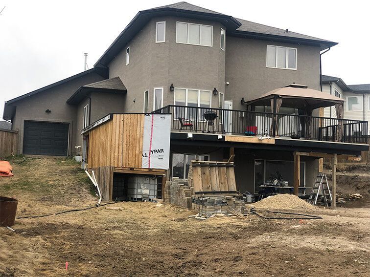 A large house with a large deck and a large yard in front of it.