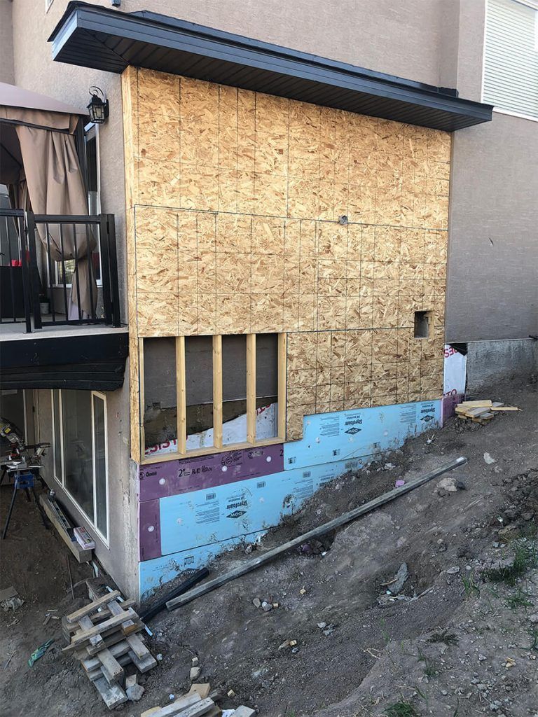 A house is being remodeled and the side of the house is covered in plywood.