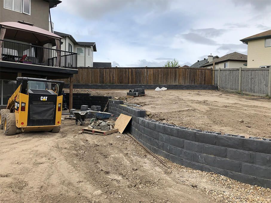 A bulldozer is parked in the dirt in front of a house.