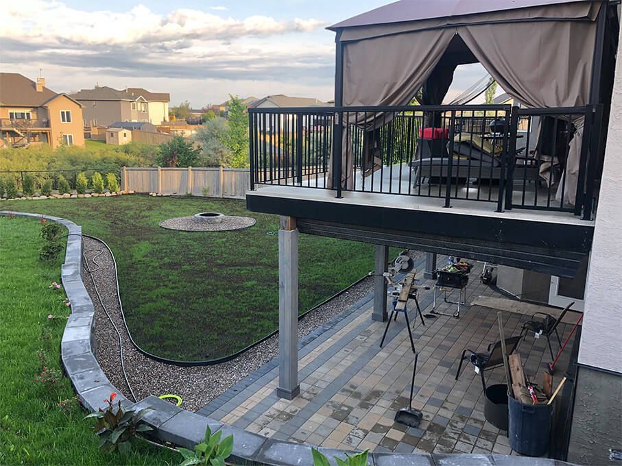A large deck with a gazebo in the backyard of a house.