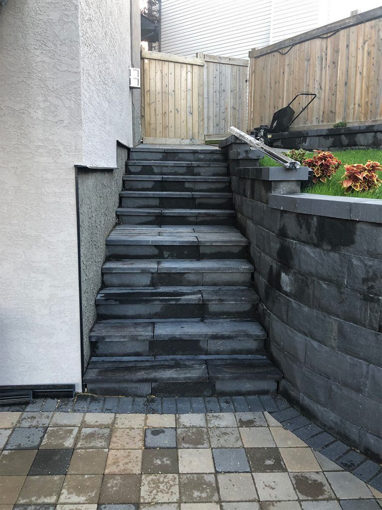 A set of stairs leading up to a fence in a backyard.