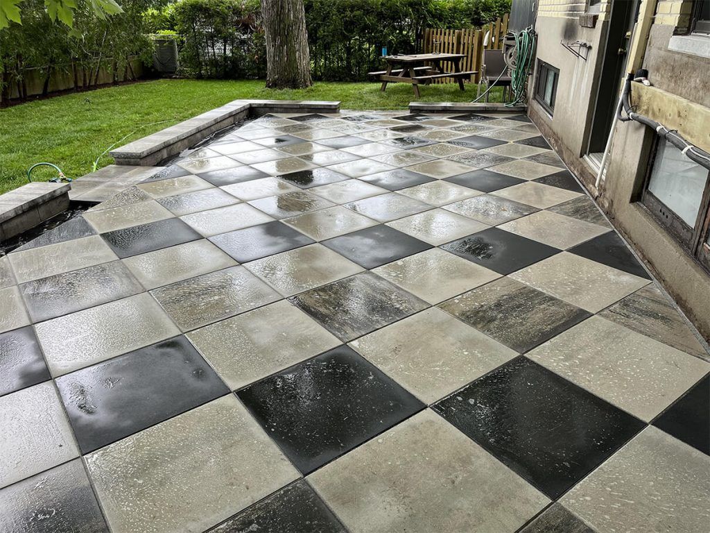 A black and white checkered patio with a picnic table in the background.