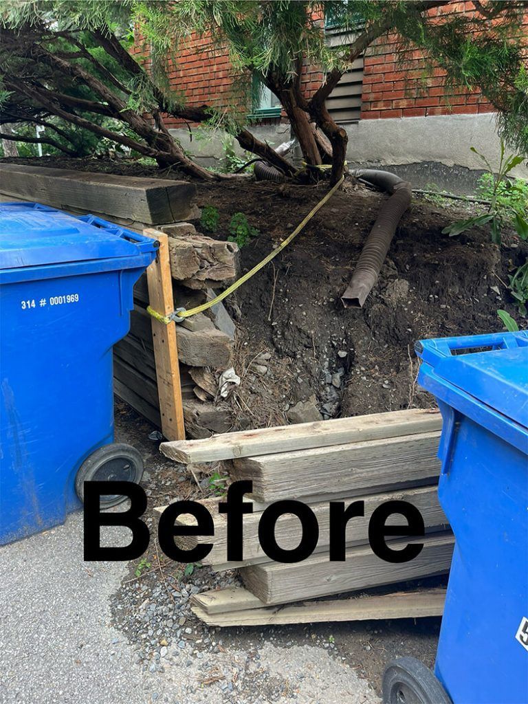 A before picture of a pile of wood and trash cans.