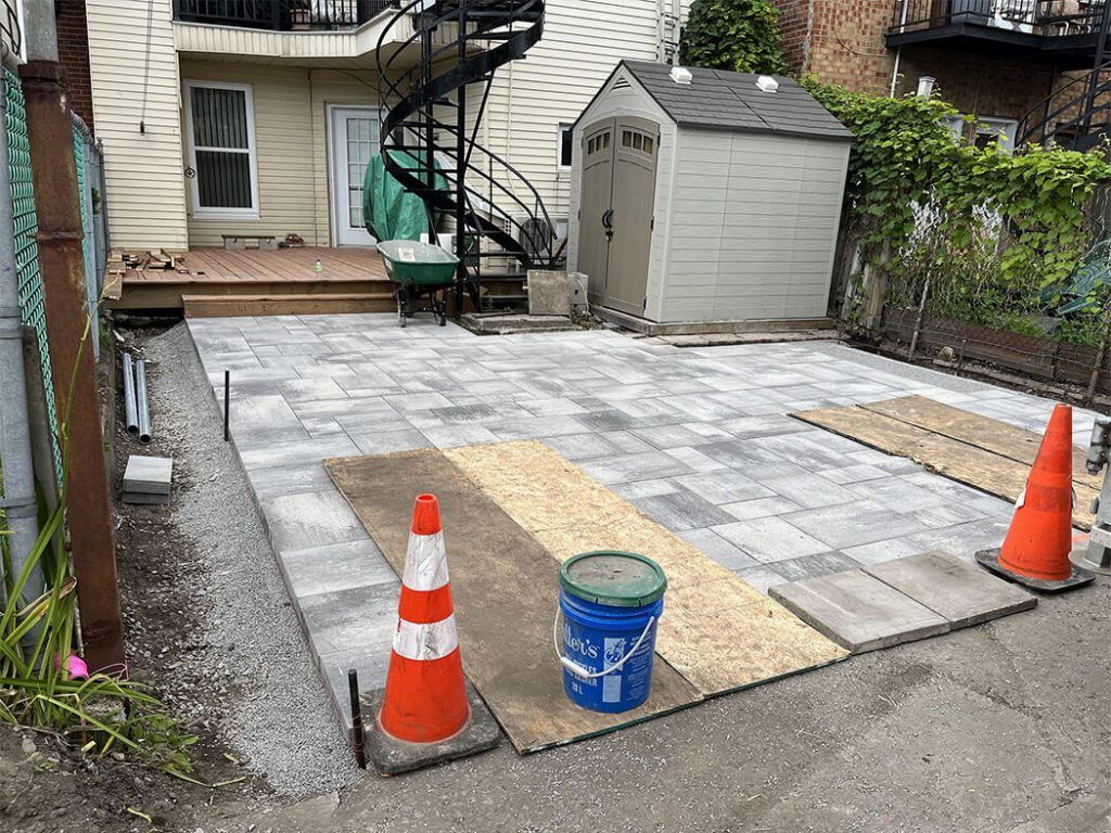 A patio is being built in front of a house.