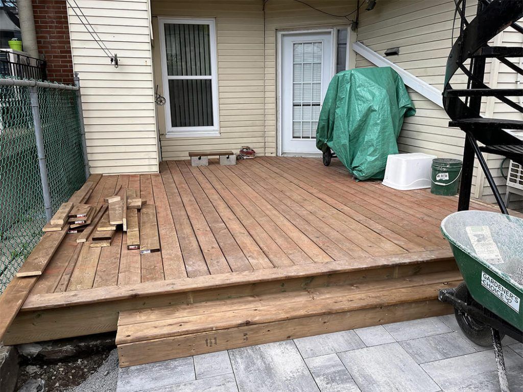 A wooden deck is being built in front of a house.