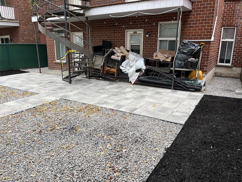 There is a staircase in the backyard of a brick building.