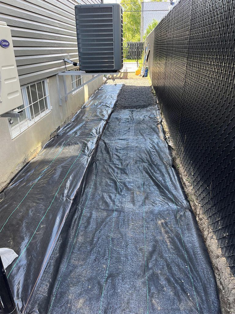 A drainage system is being installed on the side of a building.