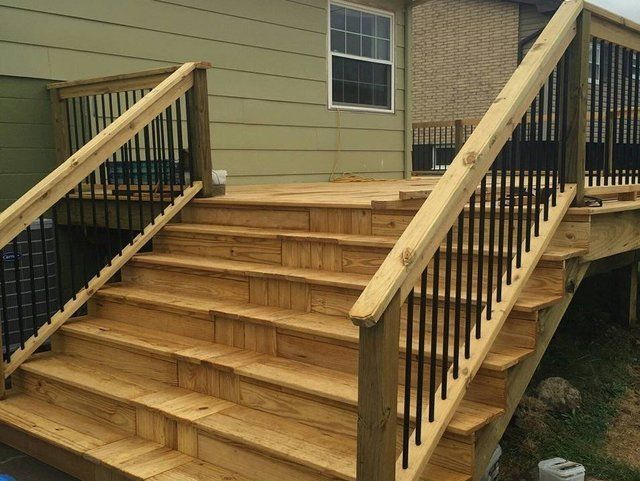 Wooden front steps and railings leading to a raised house entrance