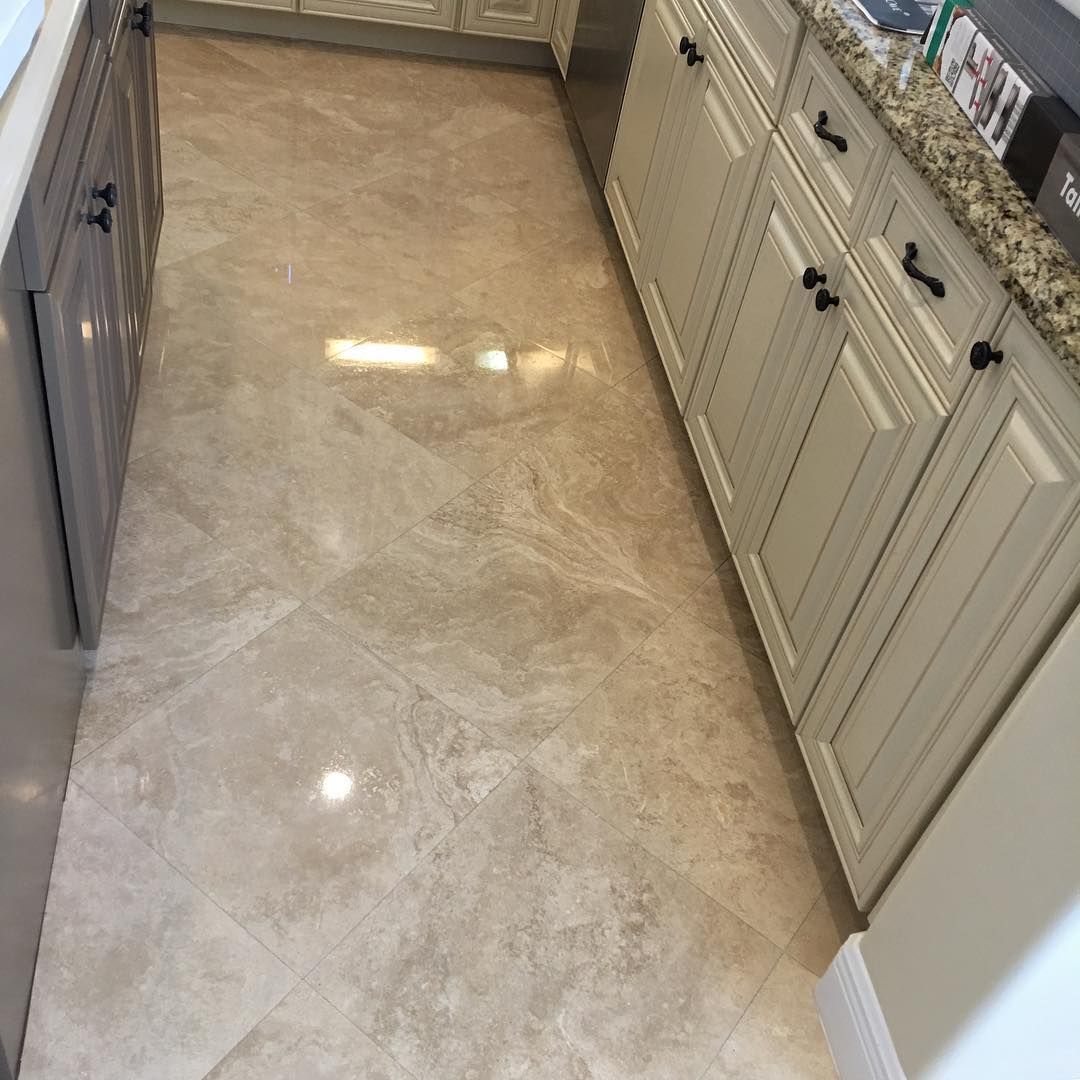 Beige tiled kitchen floor with cream cabinets and granite countertop.
