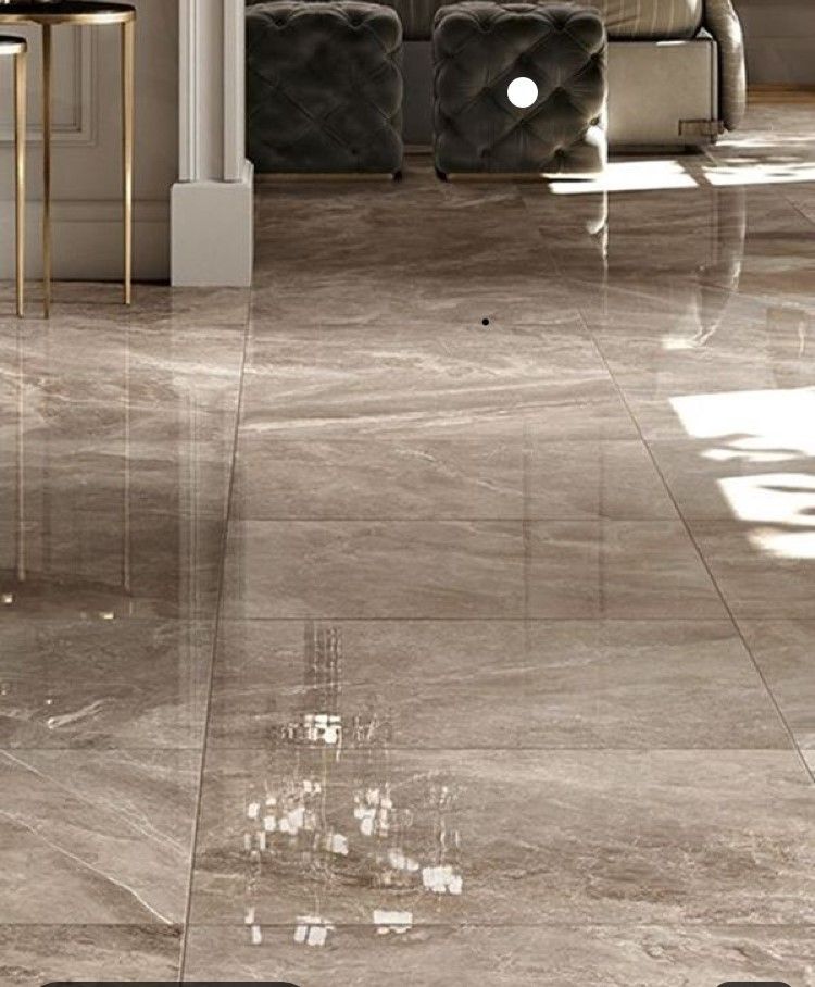 Polished gray-brown floor tiles reflecting furniture, light, and window.