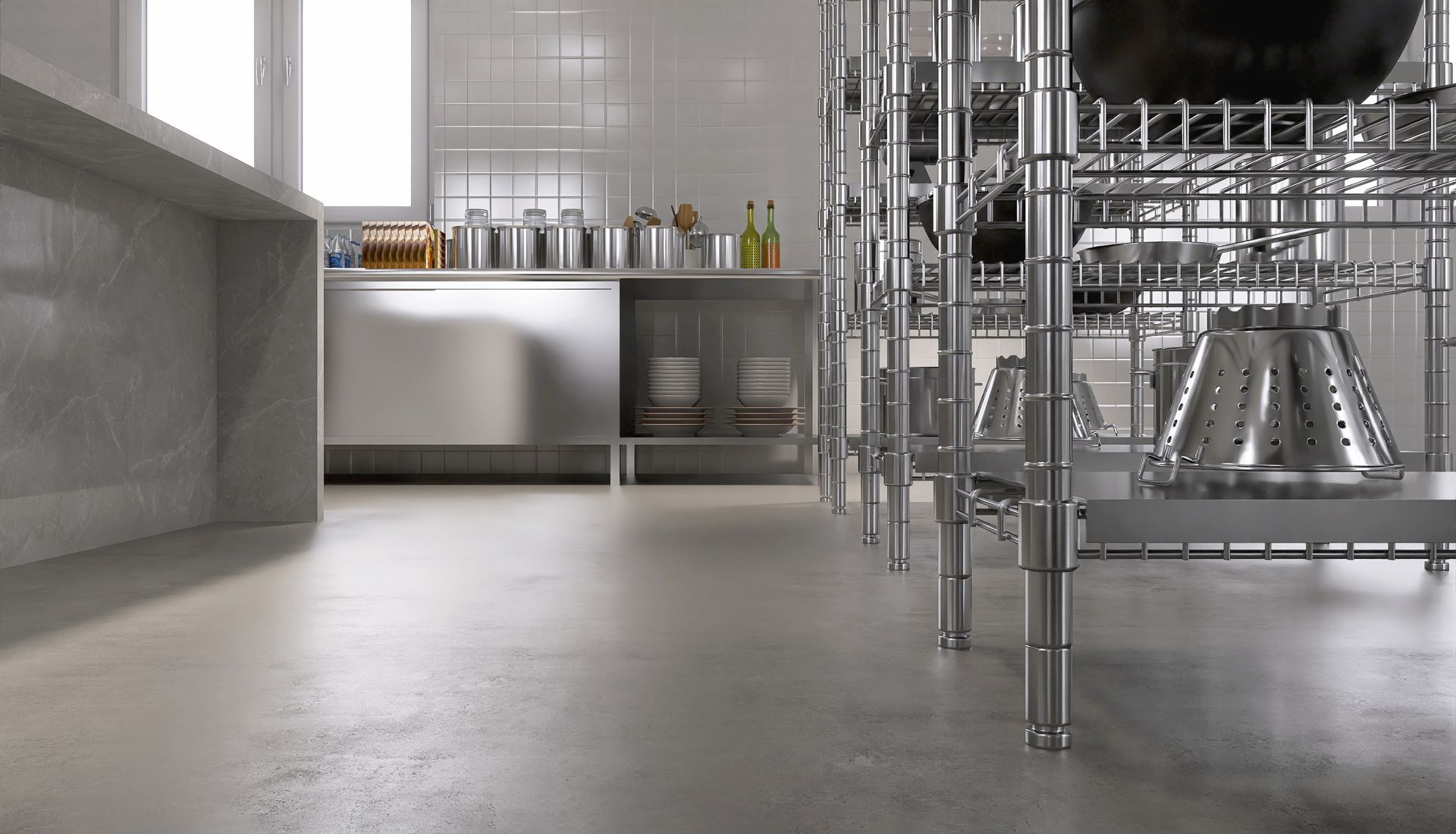 Empty modern kitchen with stainless steel counters, shelves, and metal cookware on a polished floor.