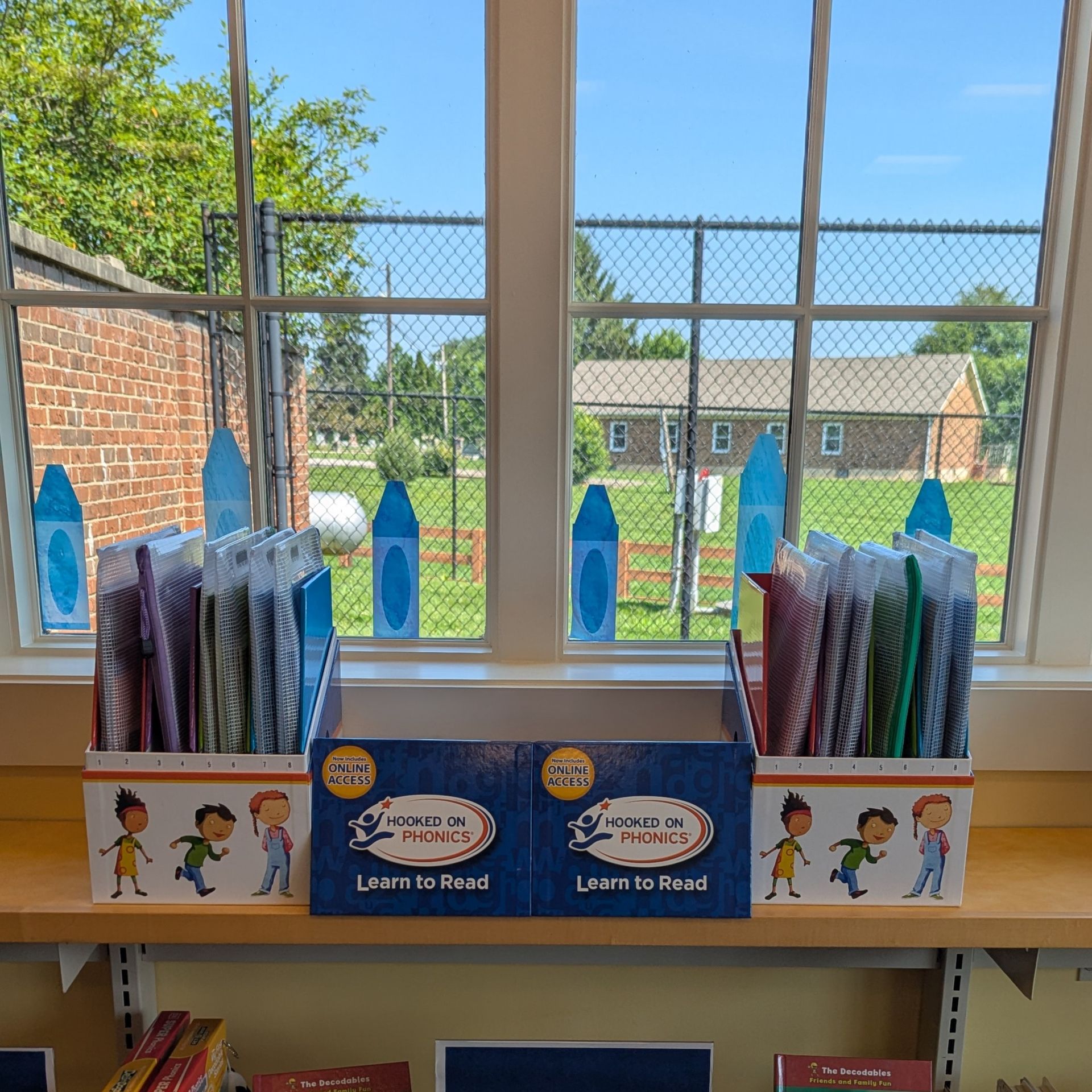 A wide view of a phonics kit display by a window.