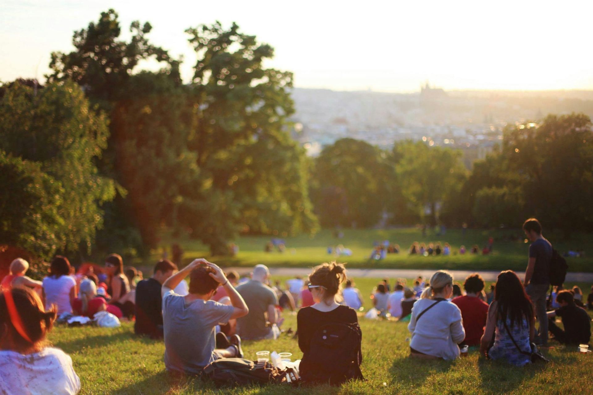 A group of people sitting on the grass in a park