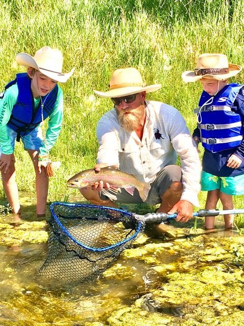 man-fishing-with-two-young-boys