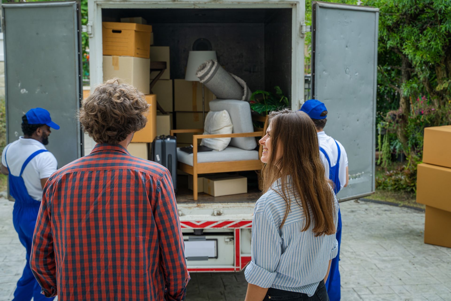 A man and a woman are standing in front of a moving truck.