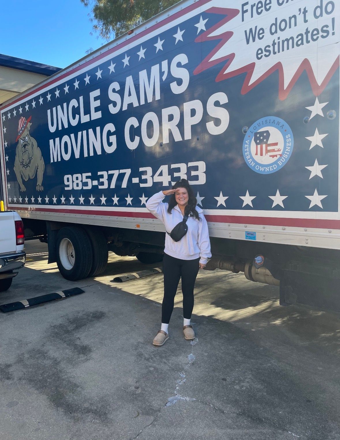 A person salutes while standing in front of a blue and white 