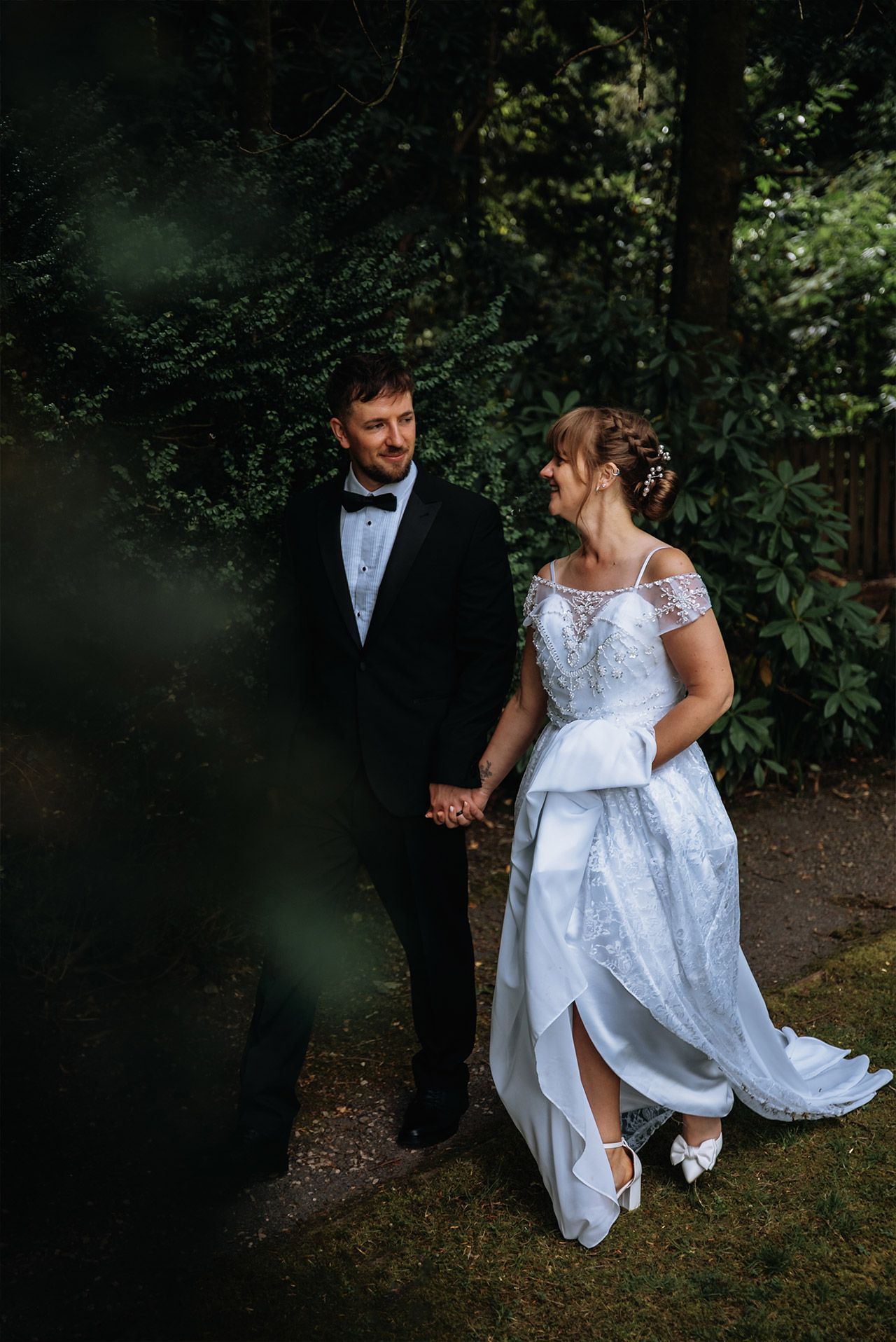 Bride and groom walking through the gardens at Briery Wood Hotel, Windermere