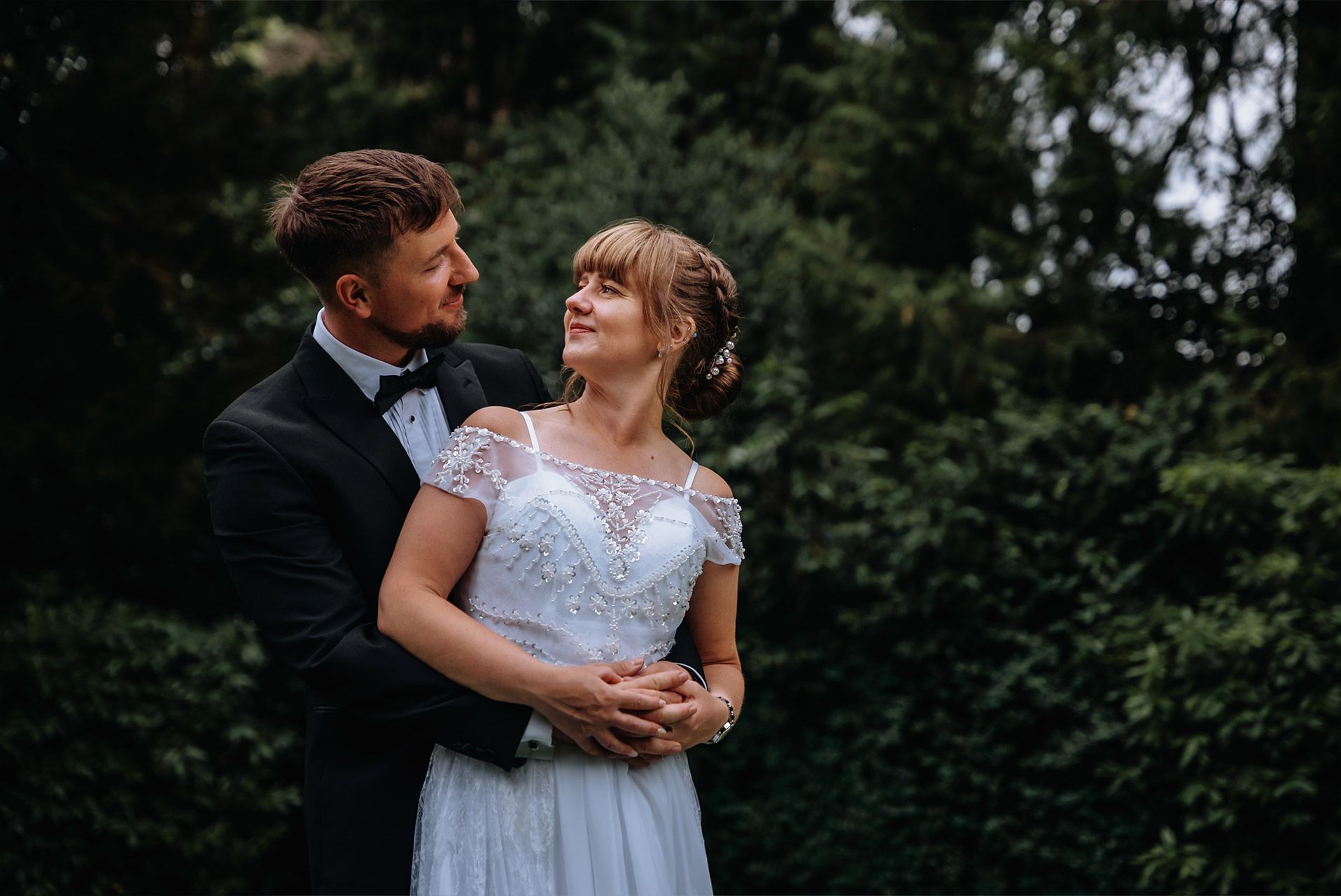 Bride and groom walking through the gardens at Briery Wood Hotel, Windermere