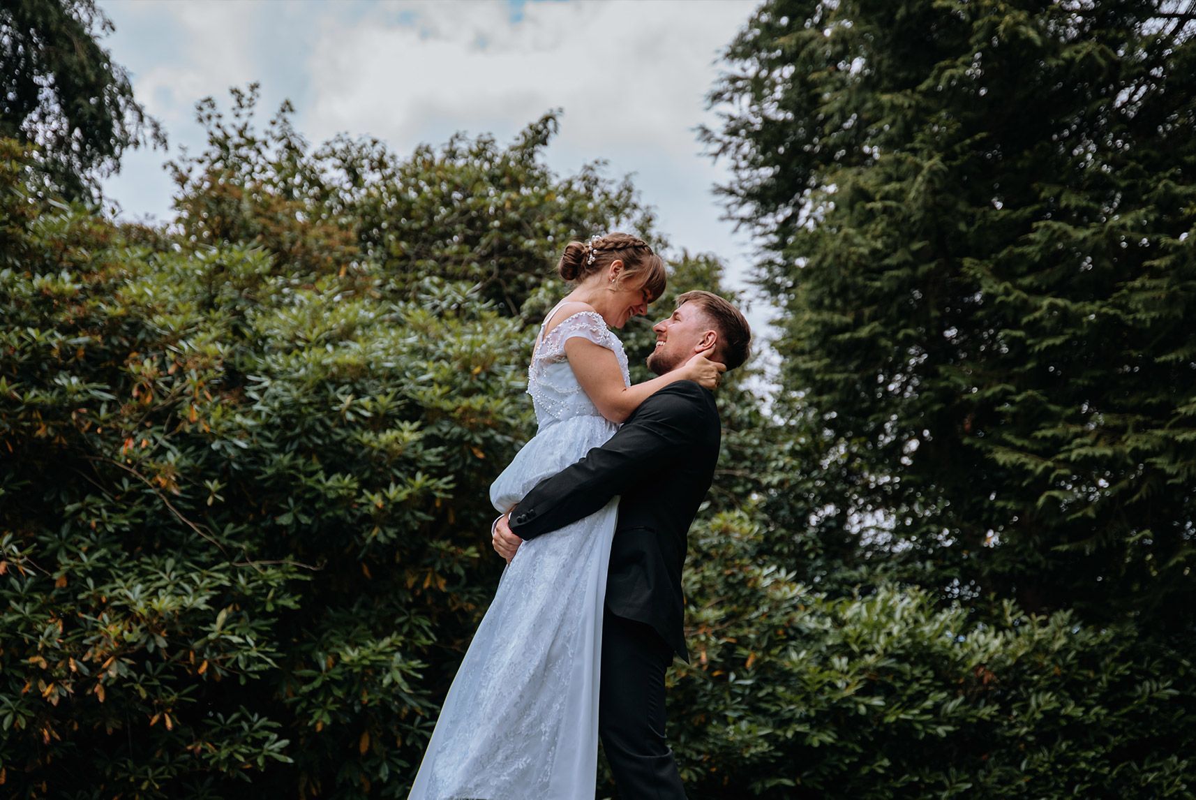 Bride and groom walking through the gardens at Briery Wood Hotel, Windermere