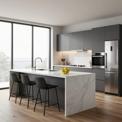 Modern kitchen with gray cabinets, marble island, black stools, and large windows.
