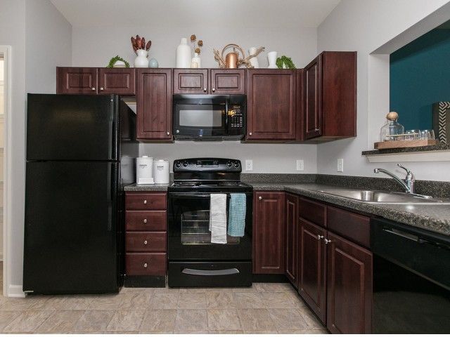 The Village at Odenton Station in Odenton, MD, offers modern apartment kitchen with dark brown kitchen cabinets.