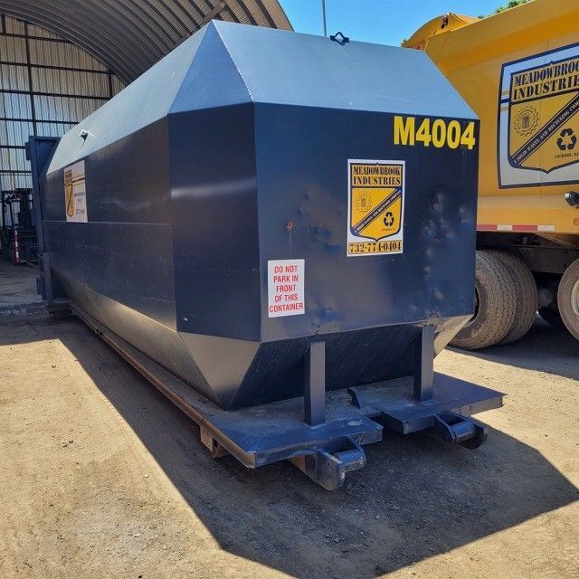 A large, dark blue, metal industrial waste container labeled 