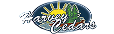 Logo for Harvey Cedars featuring a yellow sun rising over a body of water and pine trees inside a dark blue oval.