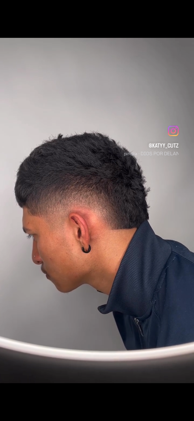 Man with a fade haircut and a black hoop earring, side profile view.