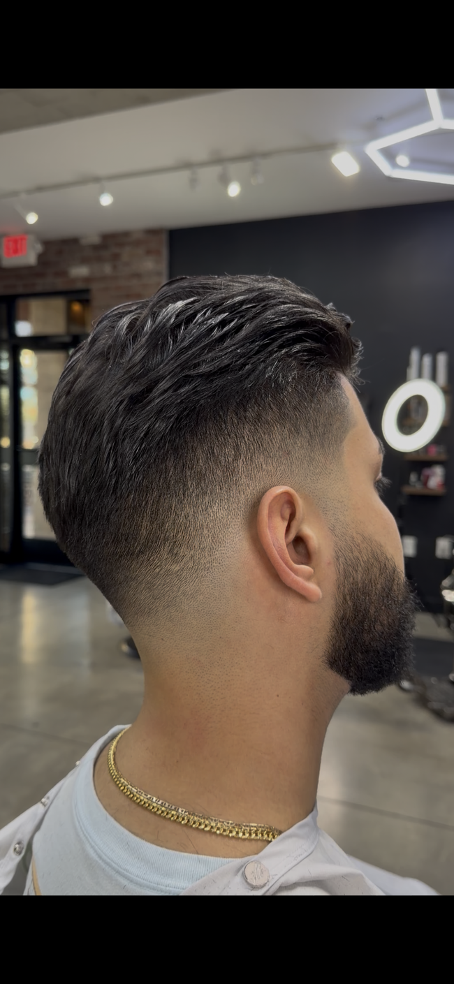 Man with a faded haircut and beard in a barber shop.