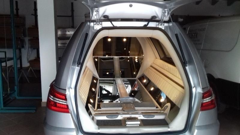 SUV argentato con portellone posteriore aperto, che mostra un allestimento interno con struttura metallica all'interno del vano di carico.