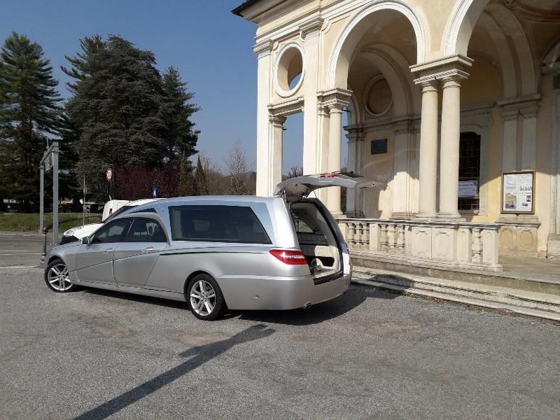 Station wagon argentata parcheggiata accanto a un edificio classico con colonne ad arco.