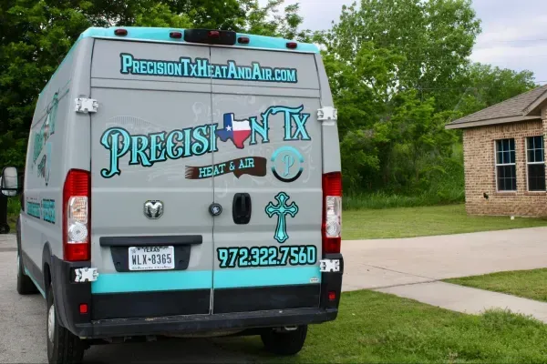 Prestige Tax van parked in a driveway, with teal and black lettering on the back.
