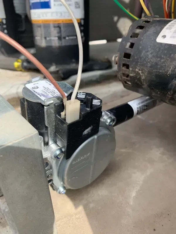 Close-up of a black and silver pump motor with copper tubing in a mechanical setup