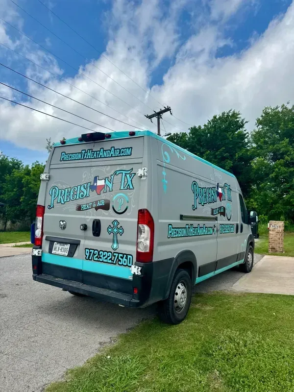 Branded white van parked on a suburban street under a cloudy sky