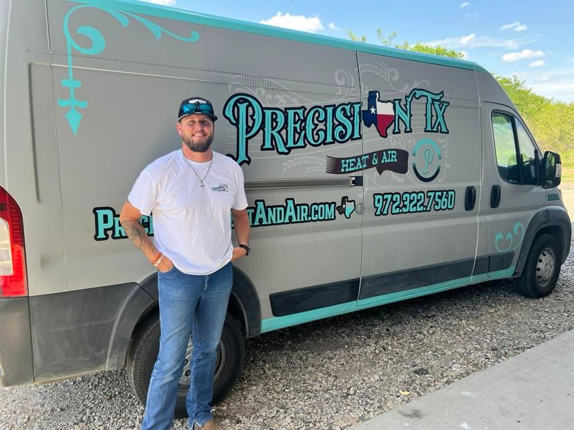 Owner, TJ, standing beside a gray Precision van with teal graphics and phone number on the side.