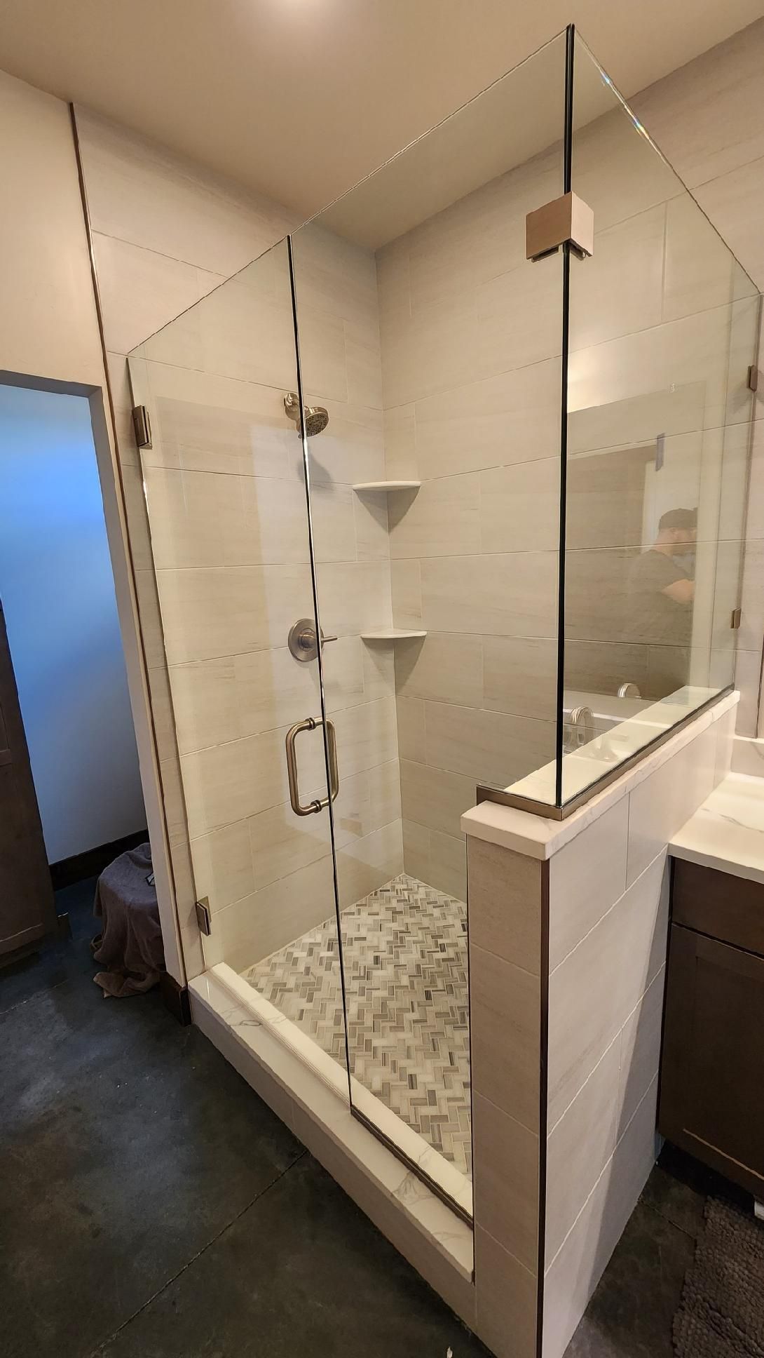 A bathroom with a walk in shower and a sink.