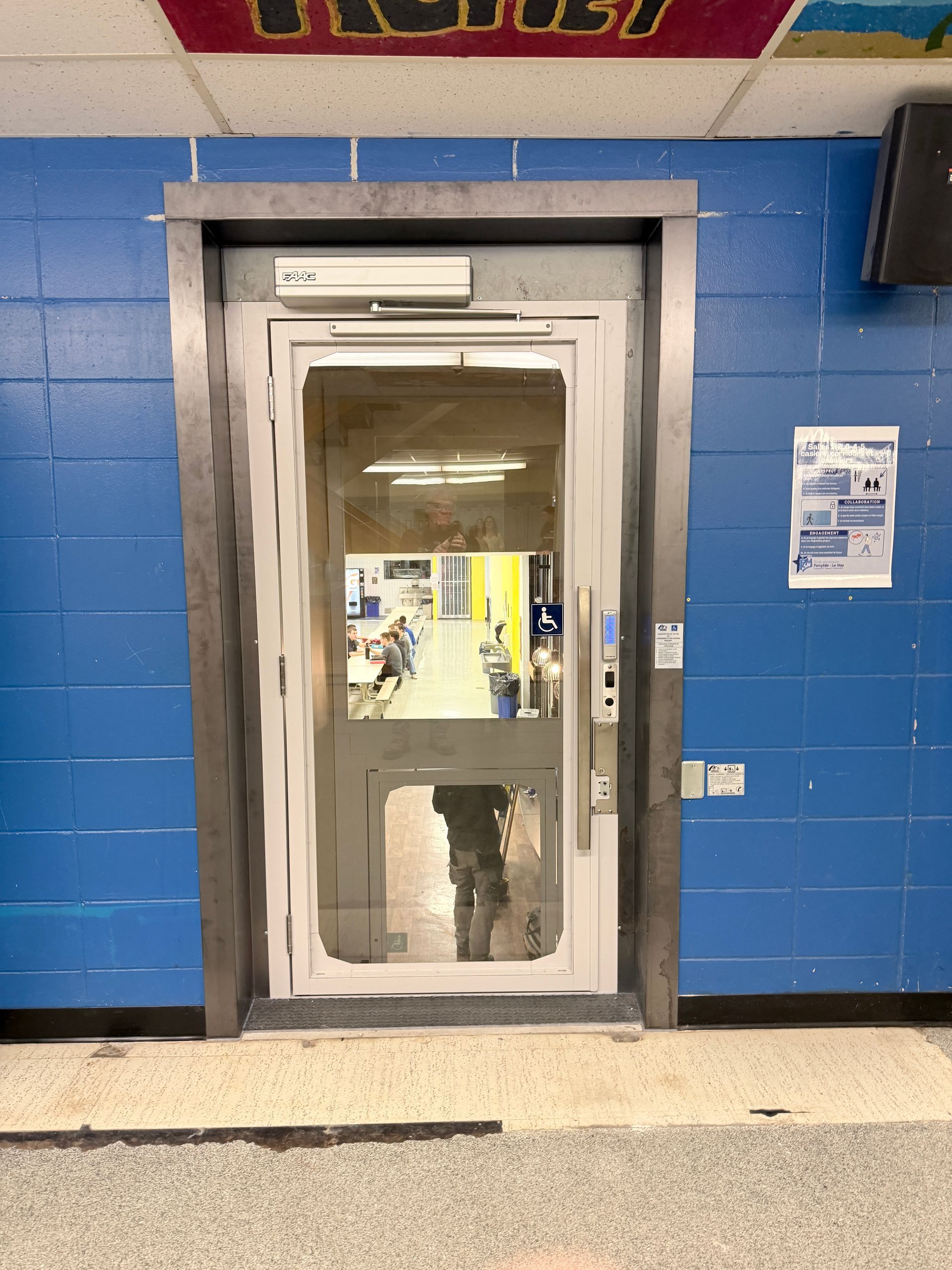 Porte extérieure bleue avec une porte vitrée et un cadre blanc dans un bâtiment en briques, probablement l'entrée d'un magasin