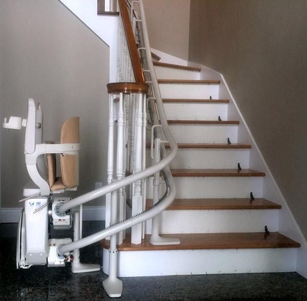 Monte-escalier incurvé à côté d'un escalier en bois dans un intérieur de maison