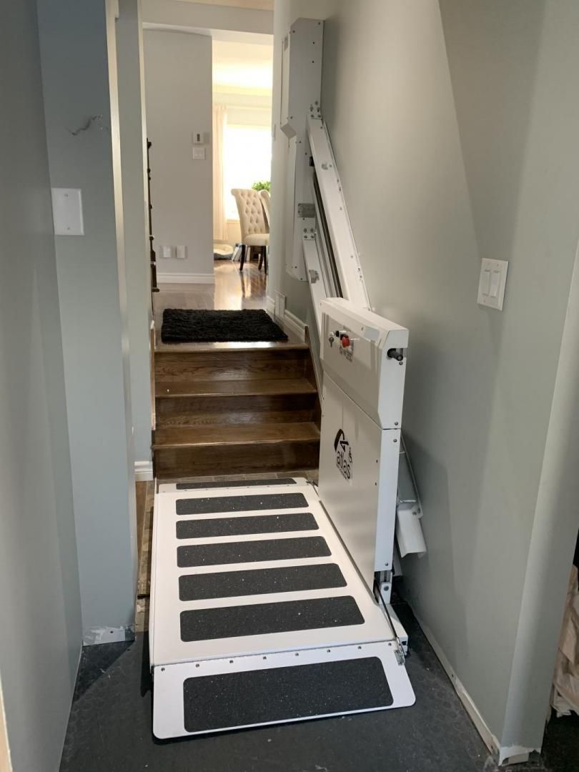 Rampe portable au-dessus des marches dans un couloir étroit menant à une porte intérieure
