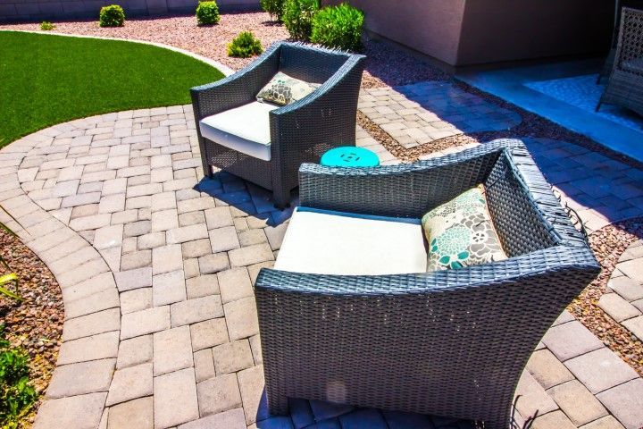 There are two chairs and a table on the patio.