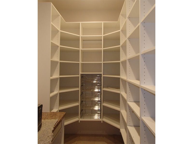 White pantry with angled shelves.
