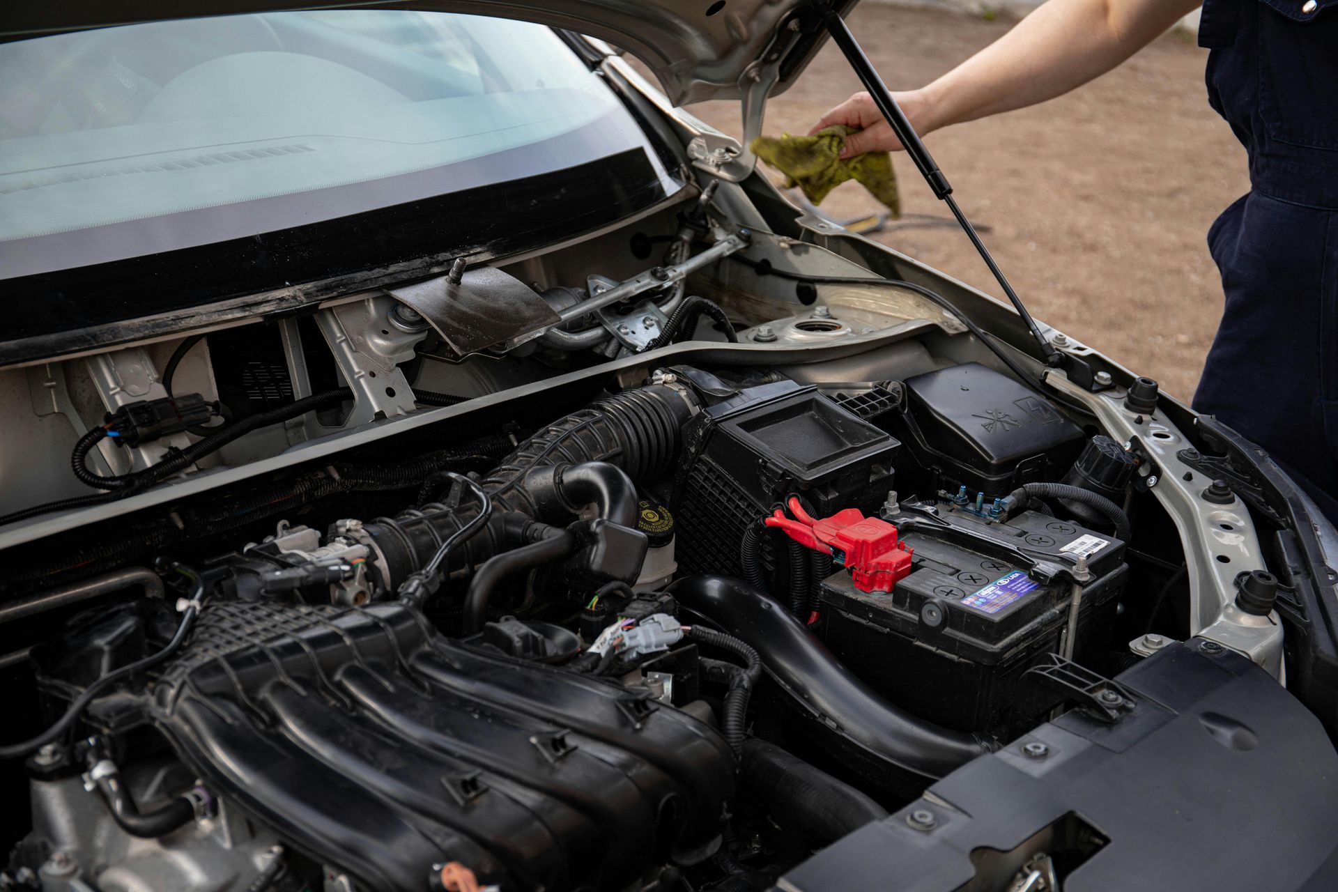 Technician Inspecting Car Battery And Engine Bay | International Motors